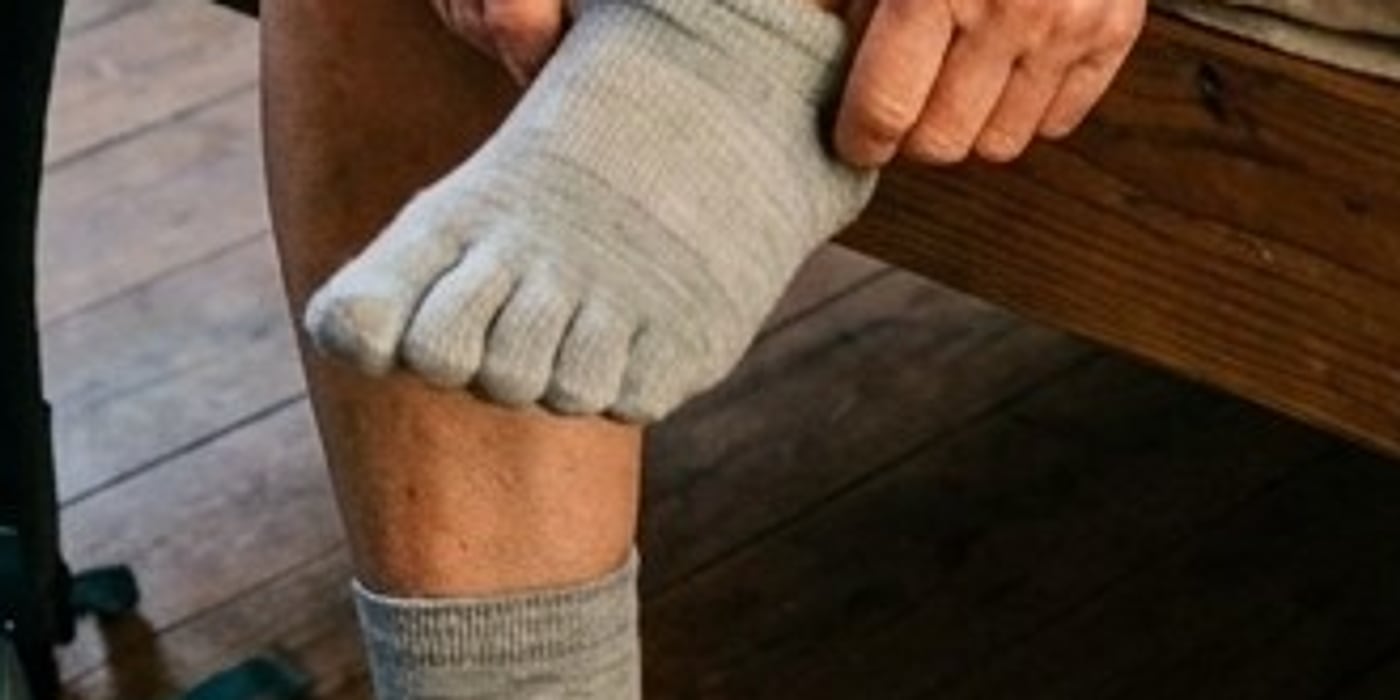 Close-up of toes in a light-gray five-toe liner sock