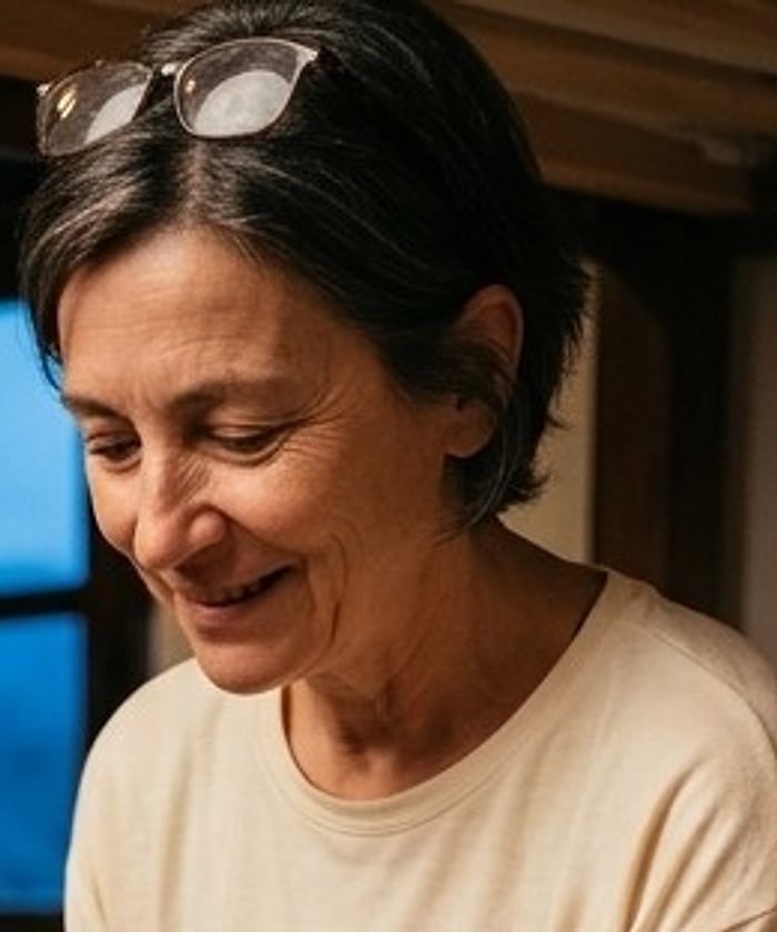 A pilgrim with reading glasses pushed up, smiling tiredly