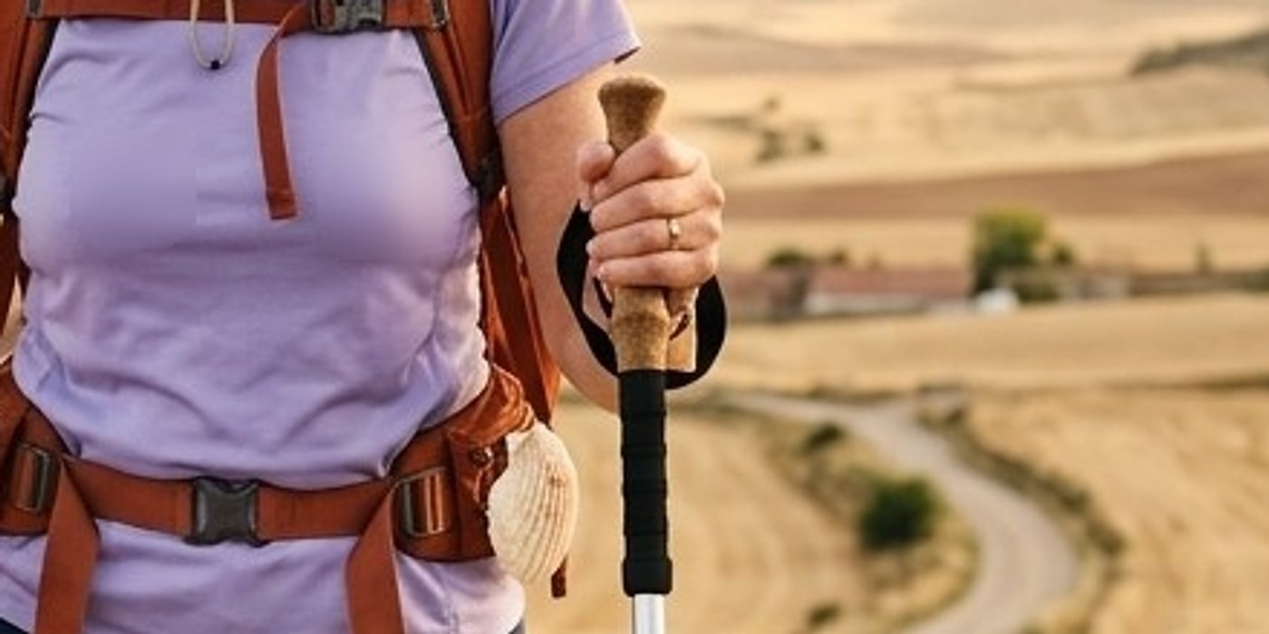 Close-up of a hand on a cork pole grip with a wrist strap
