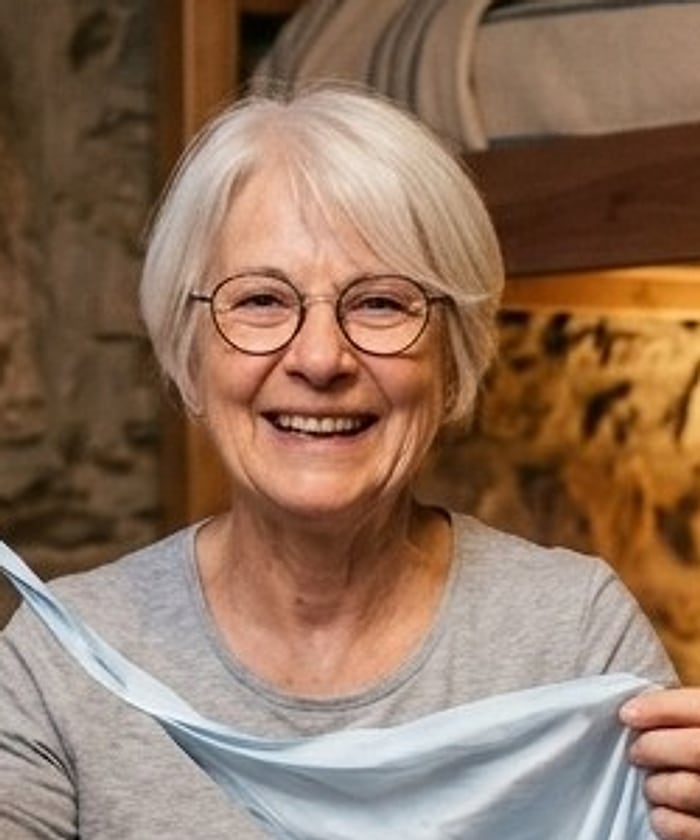 A smiling pilgrim with short white hair and round glasses