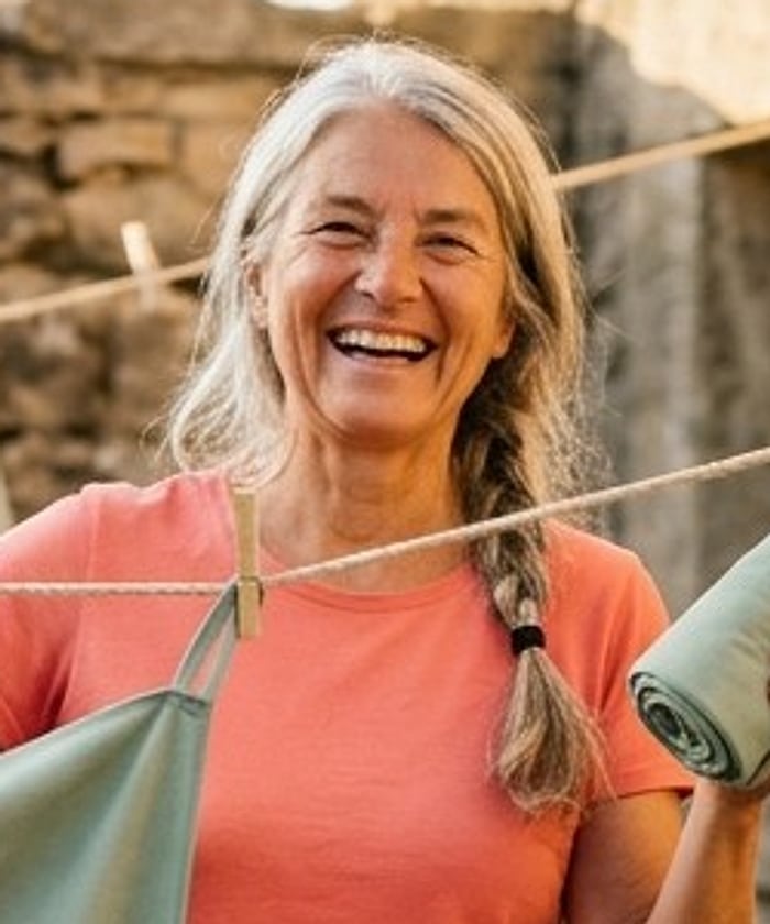 A laughing pilgrim with a silver braid in a coral t-shirt